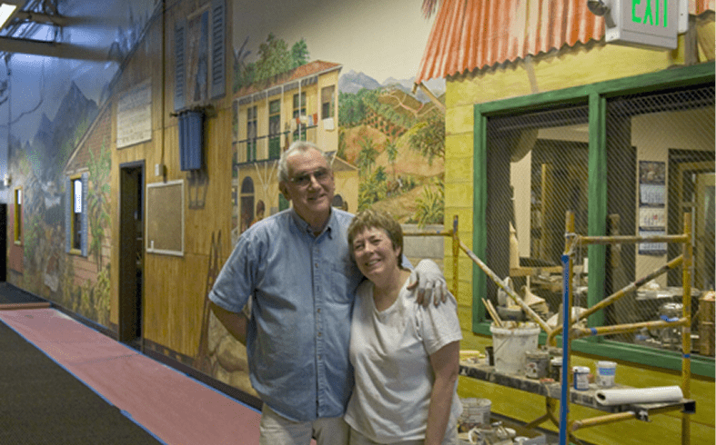 Couple smiling in colorful mural hallway