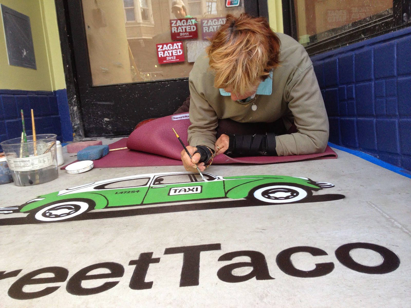 Detailed sidewalk painting of taxi by artist.