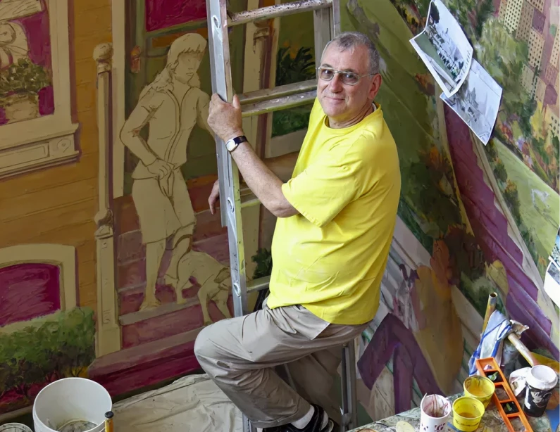 Painter working on colorful wall artwork