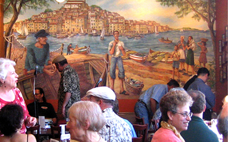 Restaurant patrons with coastal mural background