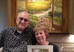 Couple holding framed landscape painting