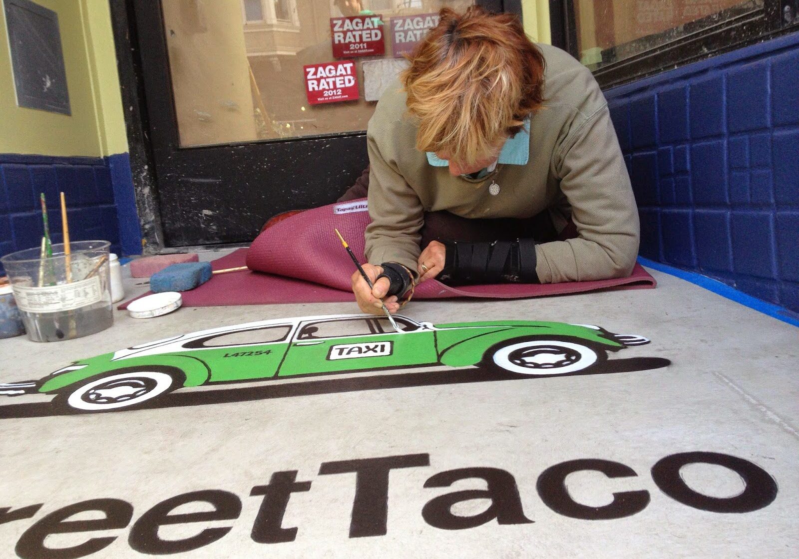 Detailed sidewalk painting of taxi by artist.